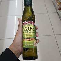 Borges Extra Virgin Olive Oil Original 250ml - Green bottle with red and white label held in hand displayed in grocery store aisle.